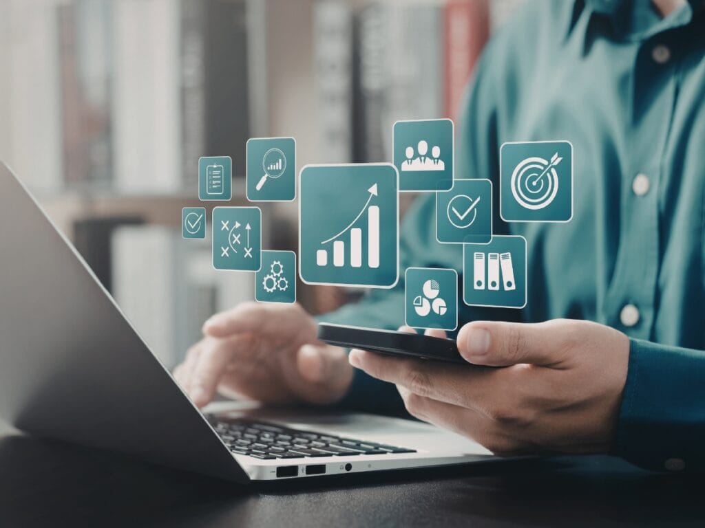 A person using a smartphone and laptop with business analytics, data visualization icons, and Digital Forensics Basics concepts digitally superimposed in front of them.